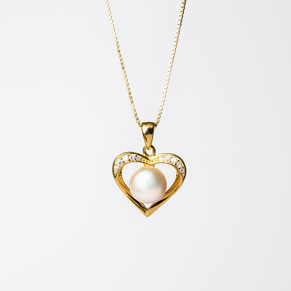 A silver necklace with a gold heart-shaped pendant featuring a pearl in the center.