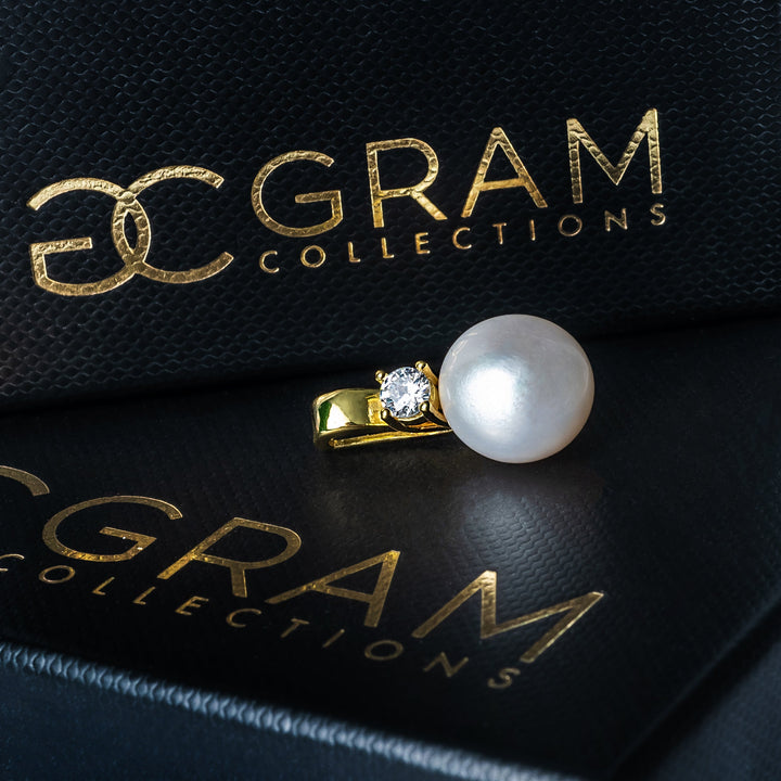 A profile view of Leonie Necklace placed on its gram collection's box. 