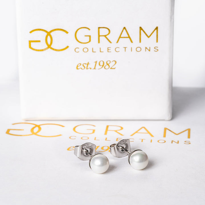 Gram Collection Lilly earrings placed on their uniquely designed white boxes. 