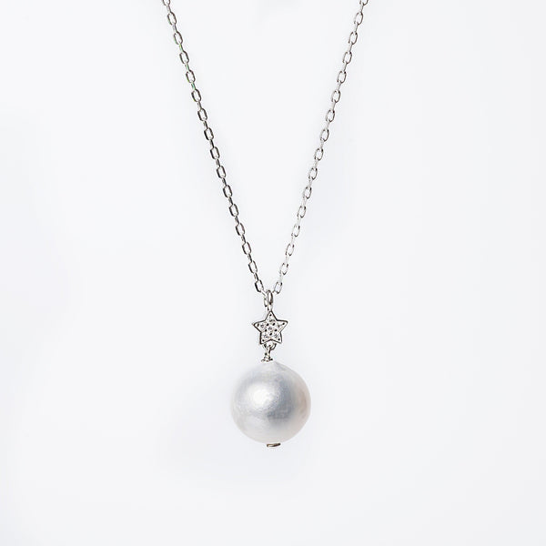 A silver Lina necklace with a single cultured pearl or cubic zirconia pendant, depending on the lighting, on a white background.