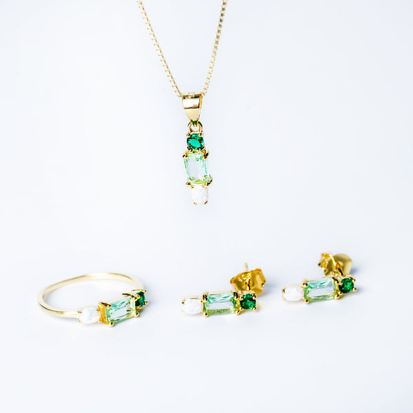 A set of jewelry including a yellow gold pendant with a green cubic zirconia and two matching yellow gold earrings with green cubic zirconia accents.