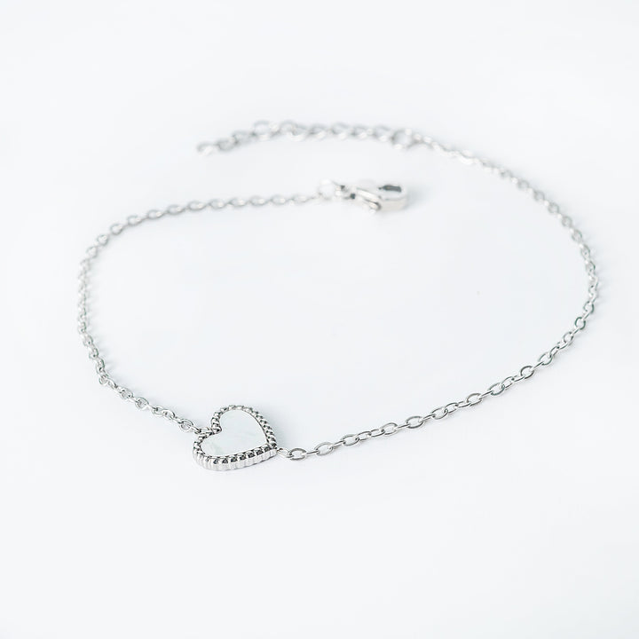 Lisa silver bracelet with an open heart pendant shown from a side angle
