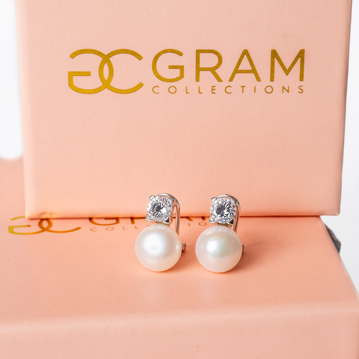 Logan earrings placed on their uniquely designed pink boxes. 