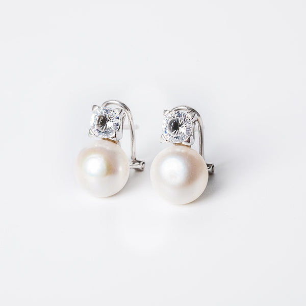 A pair of silver hoop Logan earrings with a pearl embellishment in the center, displayed against a white background.