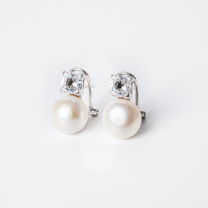 A pair of silver hoop Logan earrings with a pearl embellishment in the center, displayed against a white background.