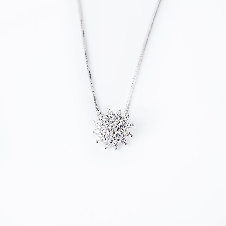 A sterling silver Lone necklace with a pendant featuring a cluster of cubic zirconia stones, displayed against a white background.