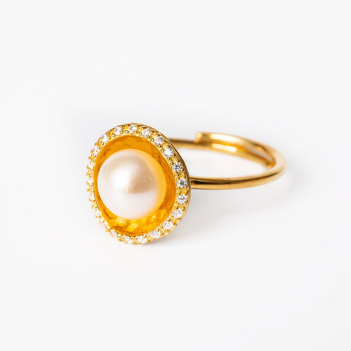 A sterling silver 925 Lorena yellow gold ring with a central cultured pearl, surrounded by AAA cubic zirconia embellishments.