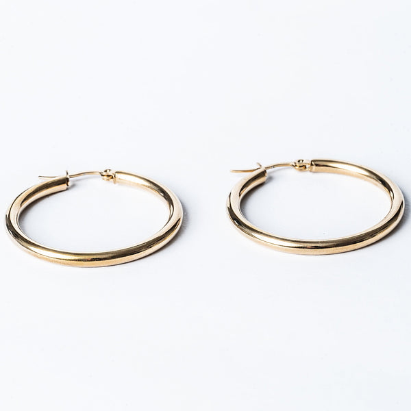 A pair of yellow gold hoop lorraine earrings on a white background