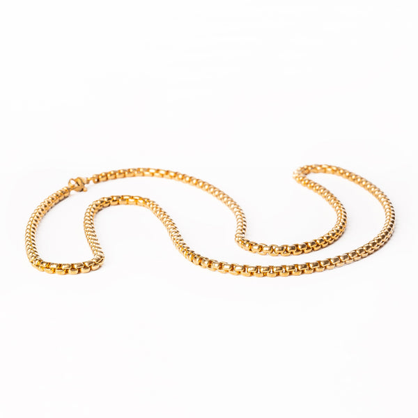 Lucca gold necklace standing in the center of the image against a white background. 
