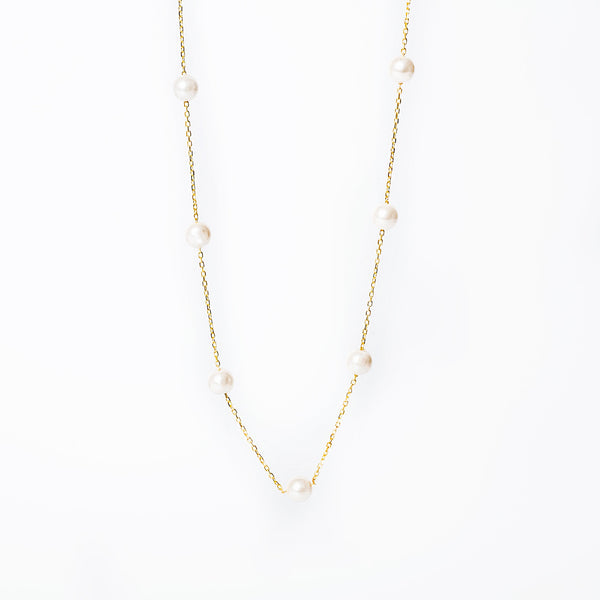 Lucille Necklace standing in the center of the image against a silver background. 