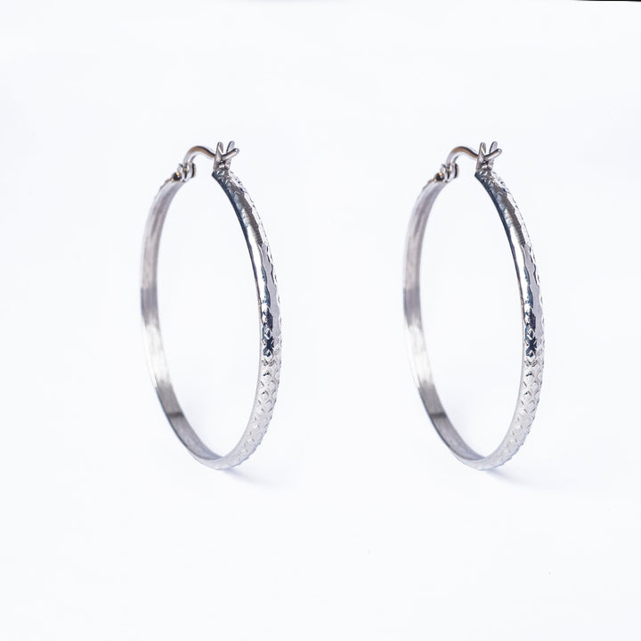 A profile view of Lucy SIlver Earrings standing next to each other in the center of the image against a white background. 