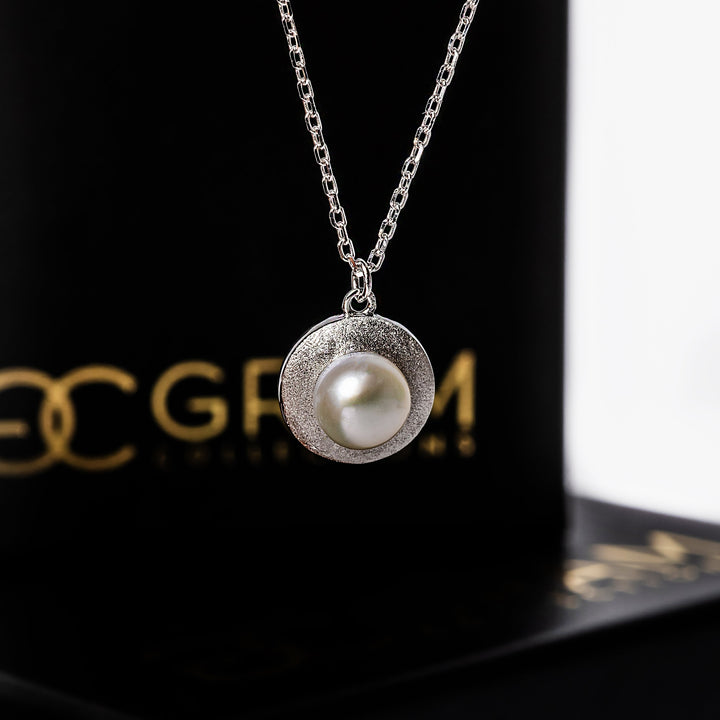 Luidsy Necklace standing in the center of the image attached to its chain
