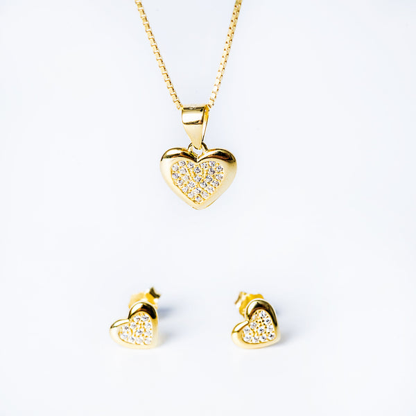 A sterling silver Lydia set with a yellow gold finish, including a heart-shaped pendant, a chain, and a pair of earrings, adorned with AAA cubic zirconia.