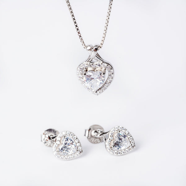 A sterling silver jewelry set including a pendant, chain, and earrings, adorned with cubic zirconia, displayed against a white background.