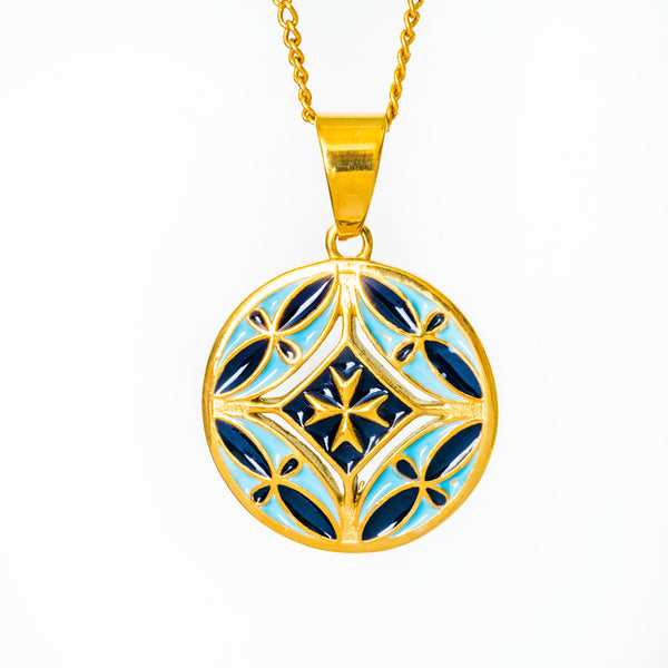 Gold Malta neckalce's pendant with blue and white design on a white background