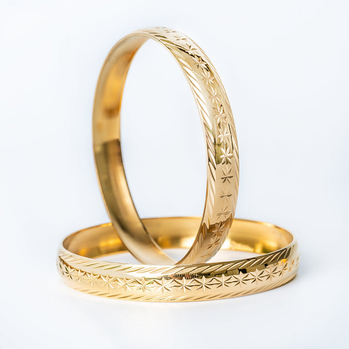 A pair of yellow gold, 18ct gold plated Maltese Fili bracelets with intricate designs, displayed against a white background.