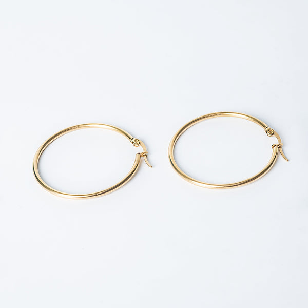 Gold Marcon hoop earrings with a smooth polished finish displayed on a white background