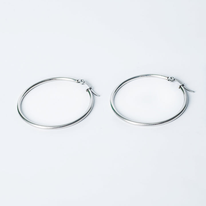 Silver Marcon hoop earrings with a smooth polished finish displayed on a white background