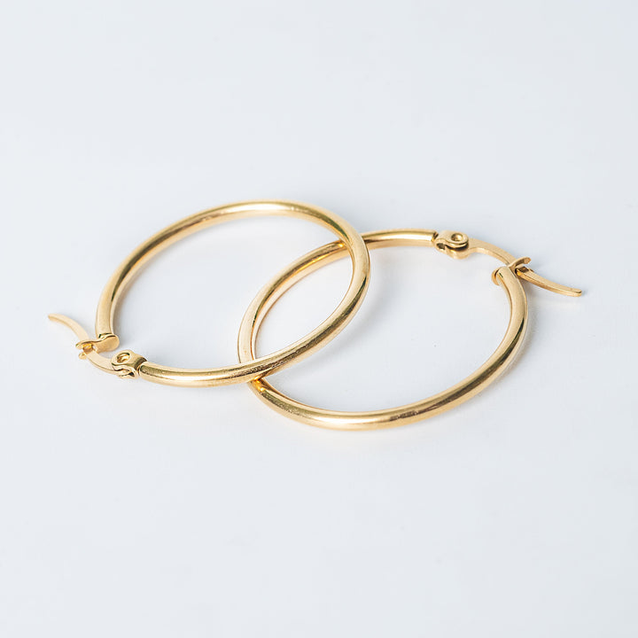 Gold Marlene hoop earrings with smooth polished finish on a white background