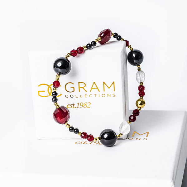 Maroon Bracelet placed over its box, standing in the center of the image against a white background. 