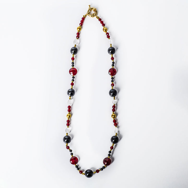 A close up view of Maroon Necklace standing in the center of the image. 