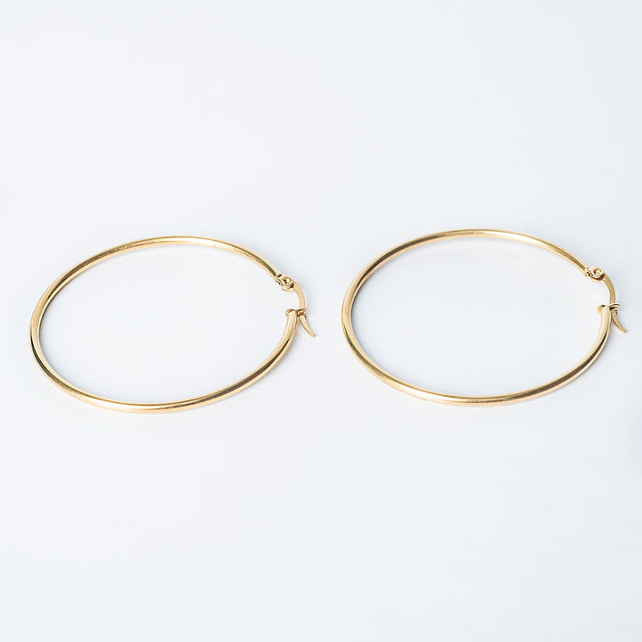 Gold Marthese hoop earrings displayed flat on a white background
