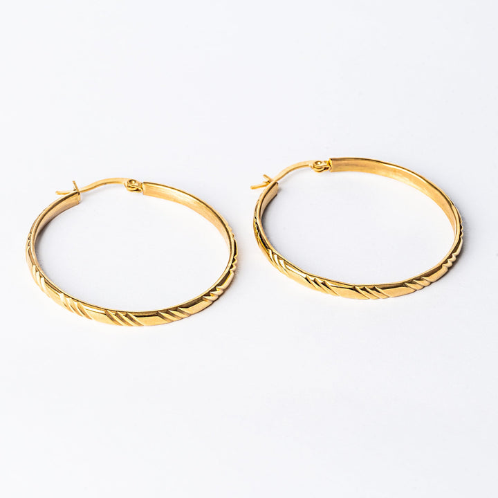 A close up view Maya Earrings standing in the center of the image against a white background. 