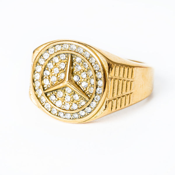 A gold-colored stainless steel Merceds ring with a geometric pattern and encrusted with cubic zirconia