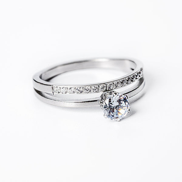 A silver-colored ring with a gold plated band and a central cubic zirconia gemstone.