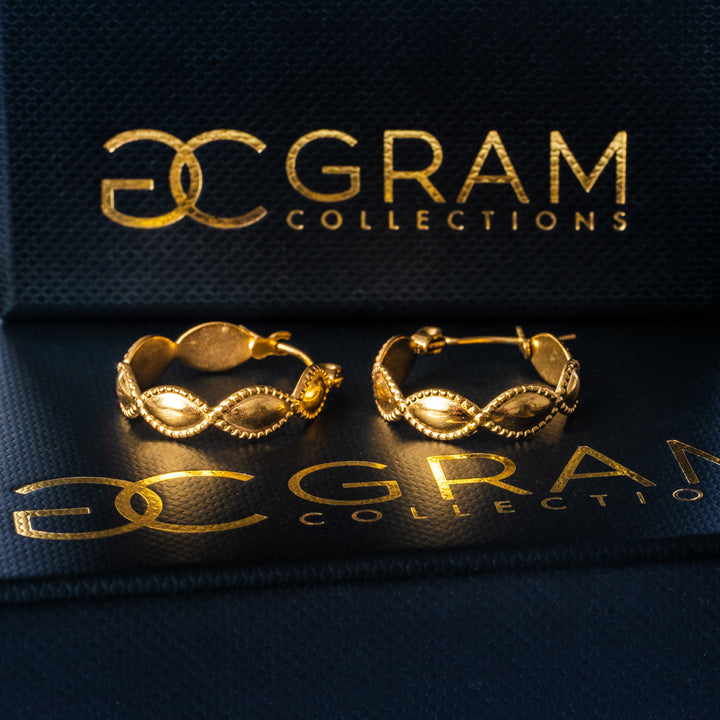 A close up view of Nakita Gold Earrings standing in the center of the image 