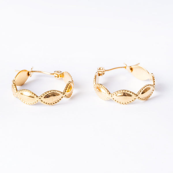 A close up view of Nakita Gold Earrings standing in the center of the image against a white background. 