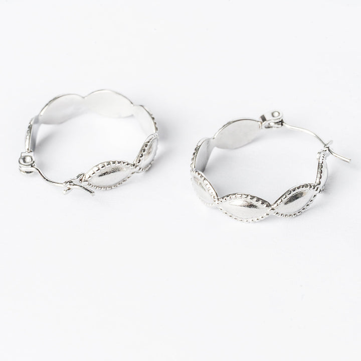 A close up view of Nikita hoop earrings standing in the center of the image, against a white background. 