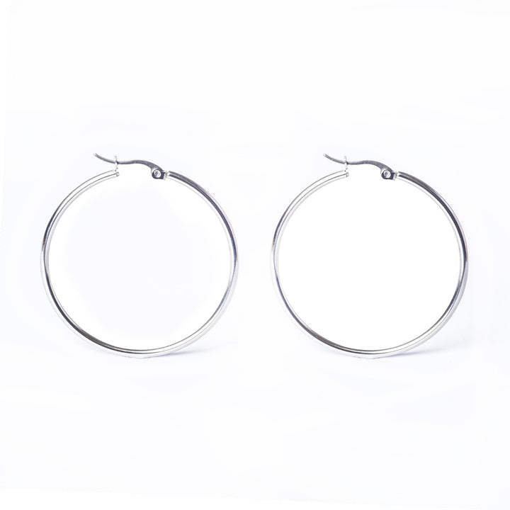A side by side view of silver earrings standing in the center of the image against a white background. 