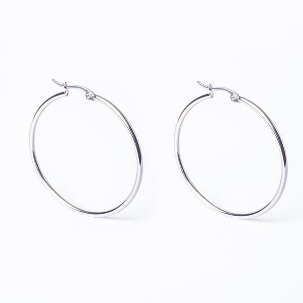 A pair of silver Olivia hoop earrings on a white background