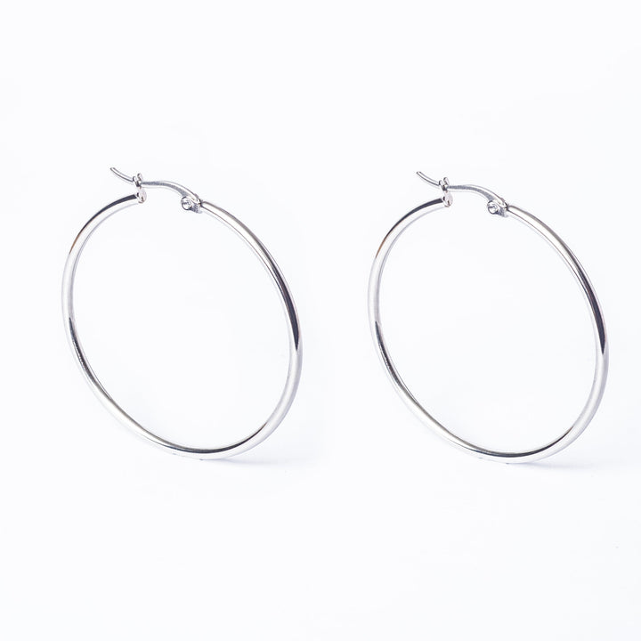 A pair of silver Olivia hoop earrings on a white background