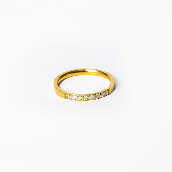 A yellow gold-plated stainless steel Paula ring with a single row of AAA cubic zirconia gems set around its circumference.