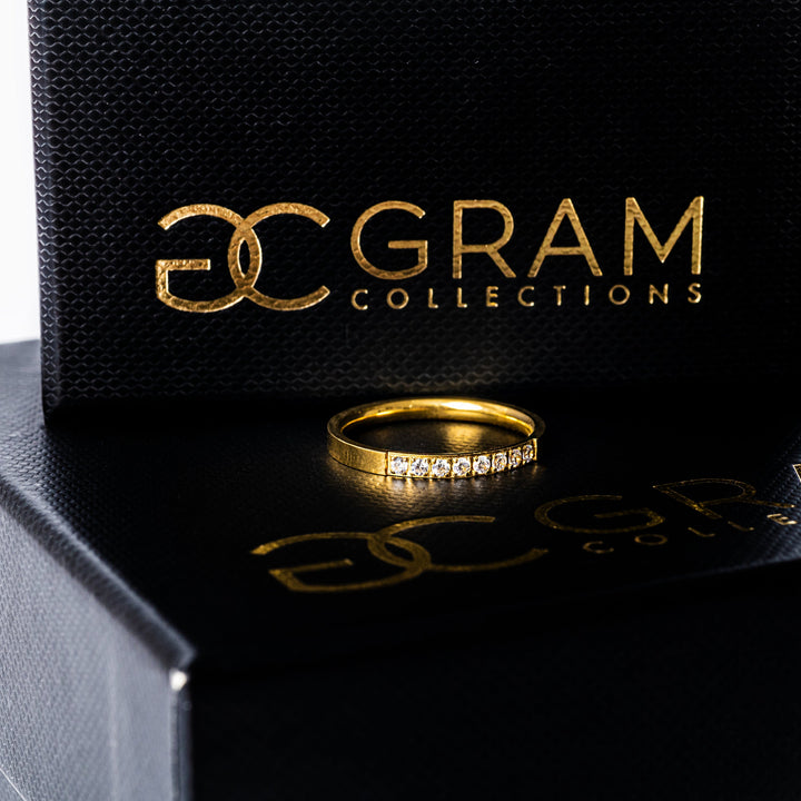 A paula gold rings standing in the center of the image, placed on its uniquely designed box. 