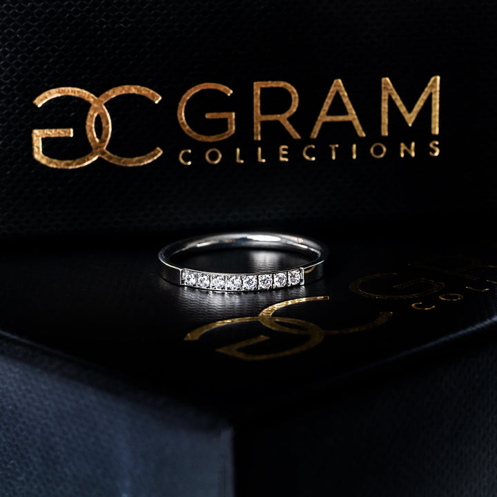 an Paula Silver Ring standing in the center of the image, while placed on its box. 