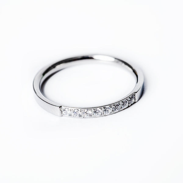 A silver-colored stainless steel ring Paula with a gold plated band, featuring a row of AAA cubic zirconia gems set around its circumference.