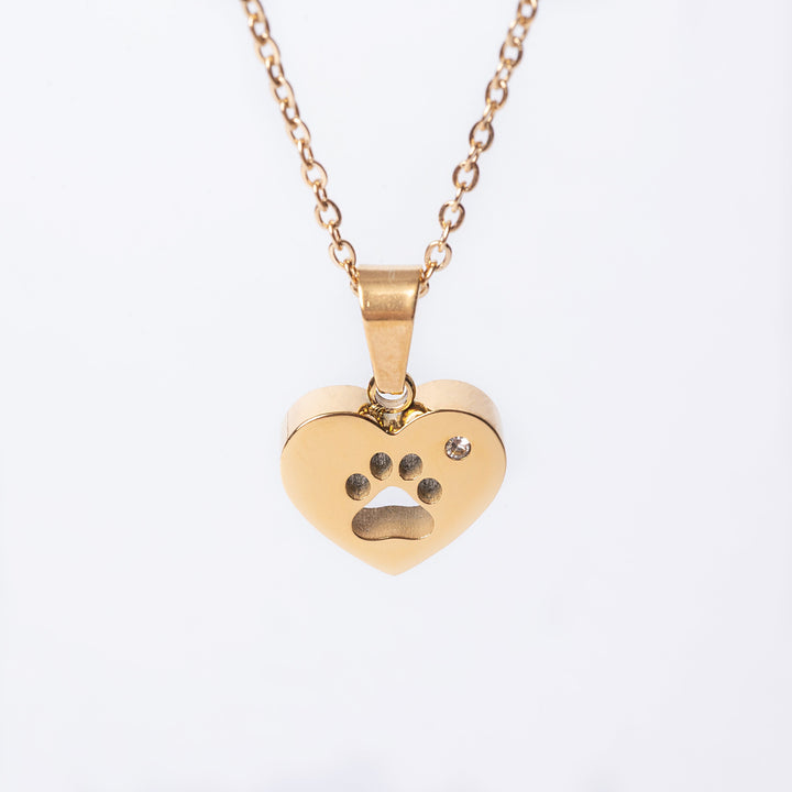 A yellow gold paw necklace with a stainless steel pendant in the shape of a heart with a paw print on it.