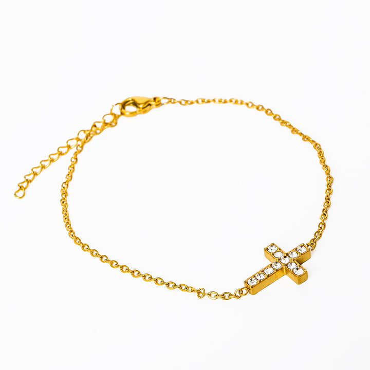 A close up view of cross shaped Raisa Bracelet standing in the center of the image against a white background. 