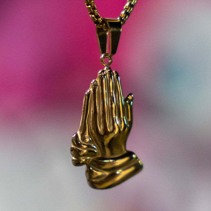 The Religious Necklace standing in the center of the image against a pink and white background bluer colour.