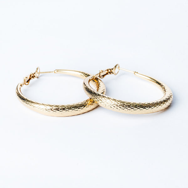 A side view of romina earrings standing in the center of the image against a white background. 