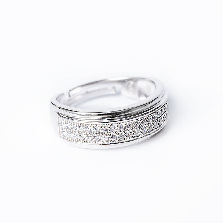 A silver ring with a band of cubic zirconia stones set around its circumference.
