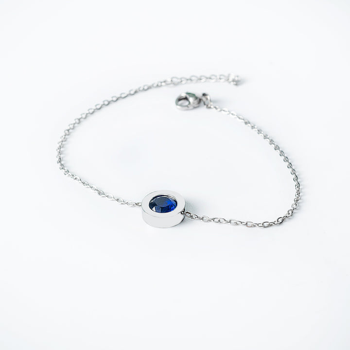 Silver Rosaria bracelet featuring a deep blue round gemstone set in a polished circular bezel on a delicate chain.
