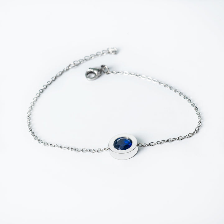 Silver Rosaria bracelet with a blue oval gemstone in a bezel setting