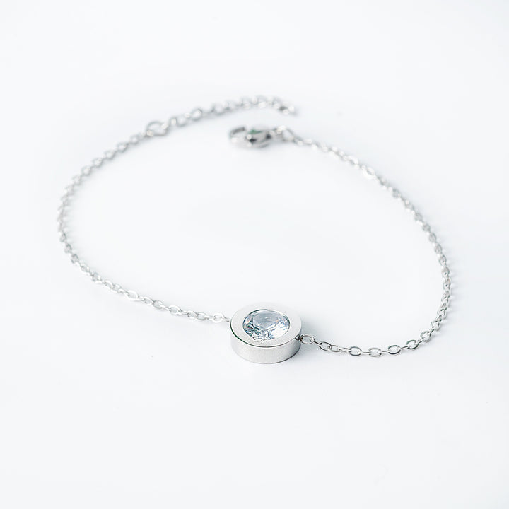 Silver bracelet with a round gemstone on a white background