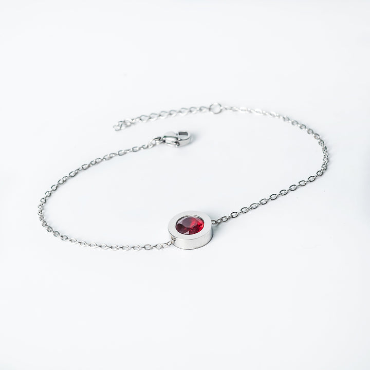 Silver Rosaria bracelet with a red gemstone centerpiece on a delicate chain