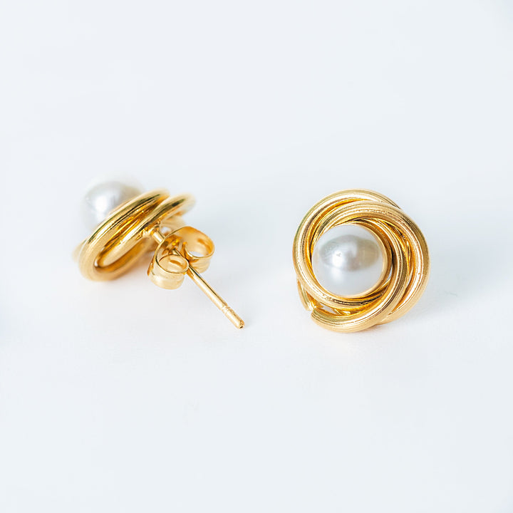 Ruth gold stud earrings with wrapped pearl design in side view