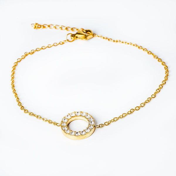 A yellow gold stainless steel Sami  bracelet with a solid pattern, featuring a circle of cubic zirconia gems.